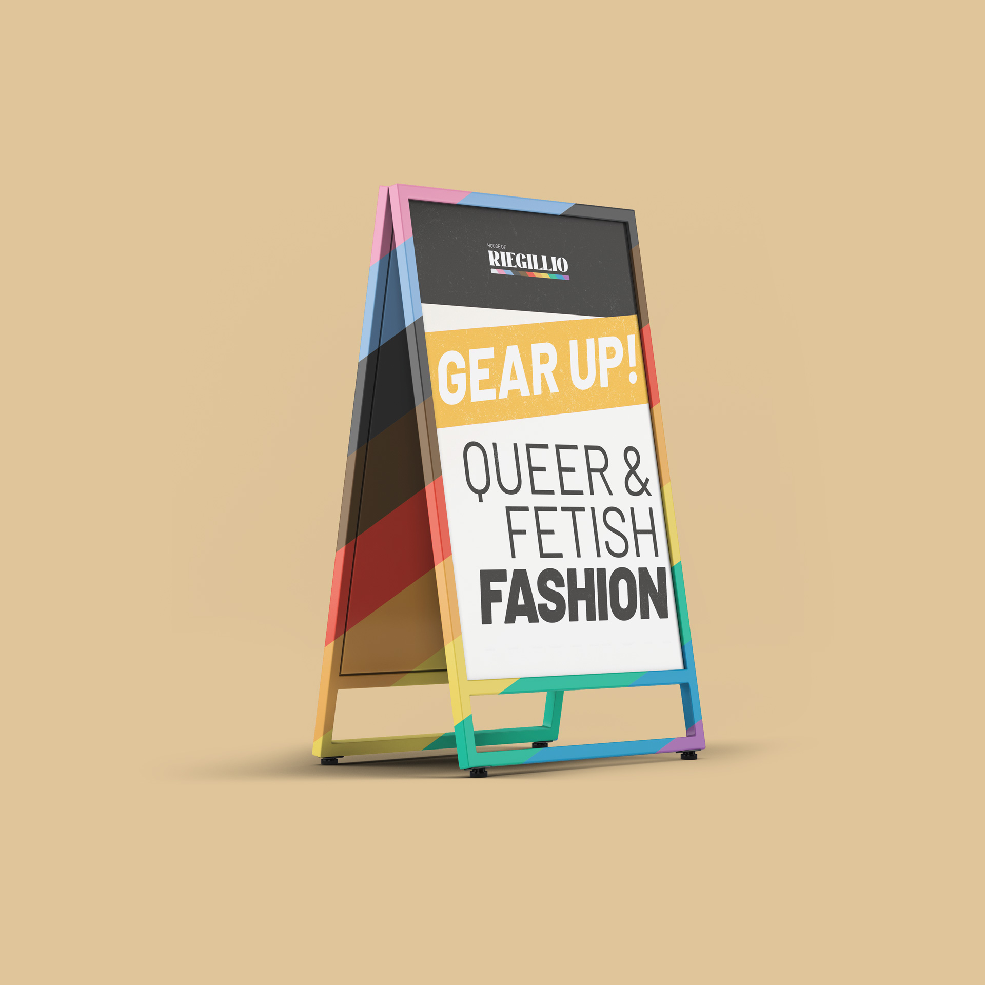 Colorful sandwich board sign on beige background with text 'Gear Up! Queer & Fetish Fashion' and House of Riegillio logo.