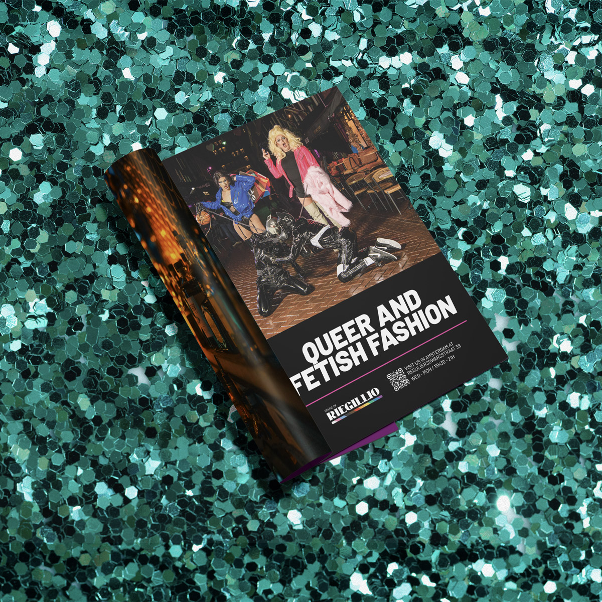 Open magazine on teal glitter background featuring an ad with three people in colorful queer and fetish fashion outfits.