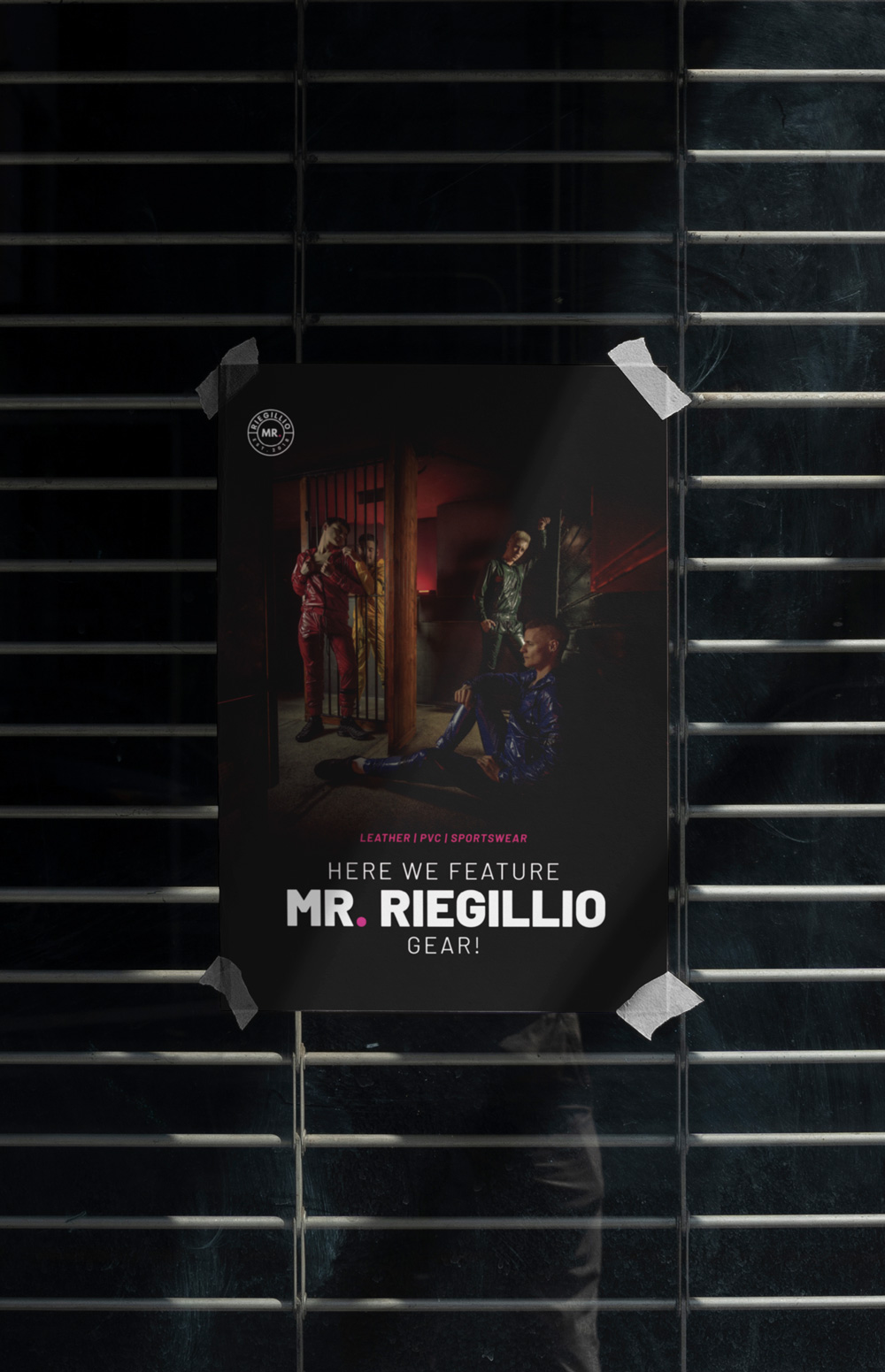 Poster taped to a metal grill showcasing four people in colorful leather and PVC sportswear with the text 'Here we feature Mr. Riegillio gear!'