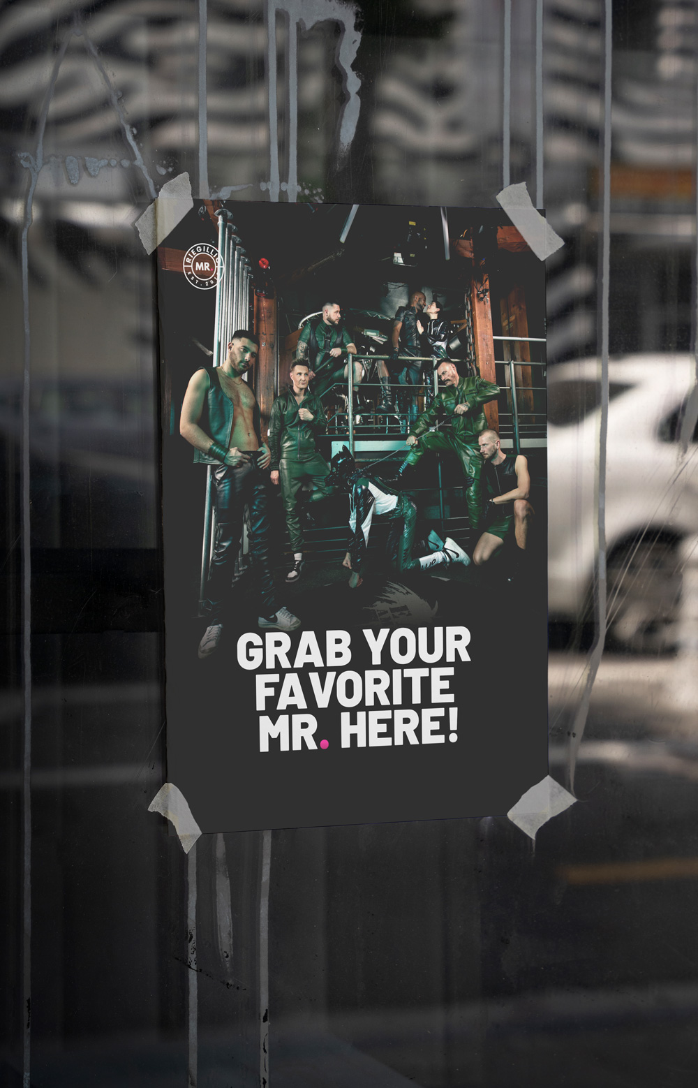 Poster taped to a window featuring a group of people dressed in leather and latex with the text 'GRAB YOUR FAVORITE MR. HERE!' in bold white letters.
