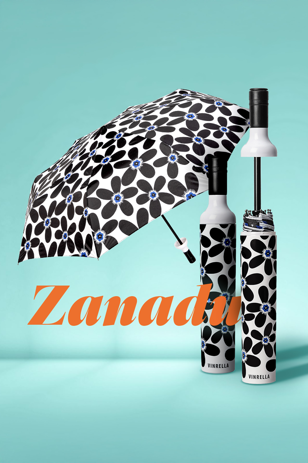 Black and white floral patterned umbrella with blue centers displayed with matching cylindrical cases against a turquoise background, featuring the word Zanadu in orange text.