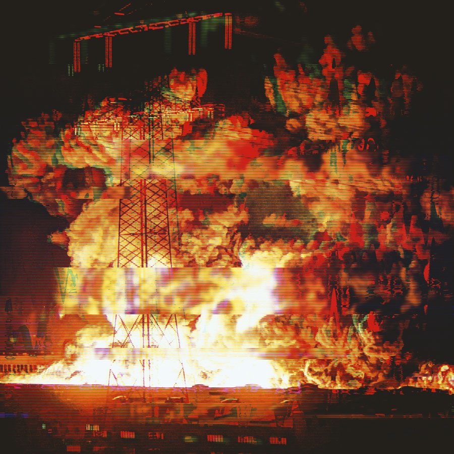 Large explosion with intense orange flames and thick smoke surrounding a metallic tower structure.