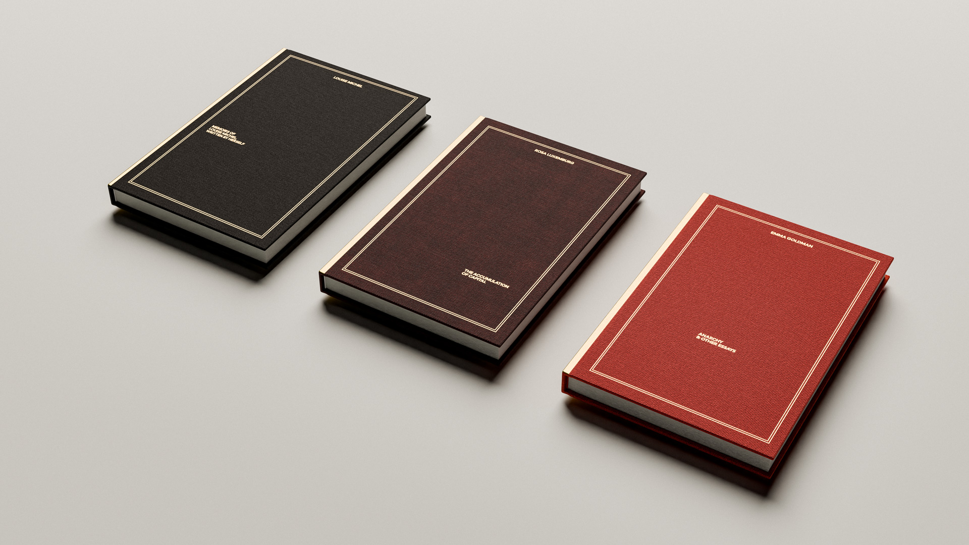 Three hardcover books with textured covers in black, dark brown, and red, displayed on a light surface.