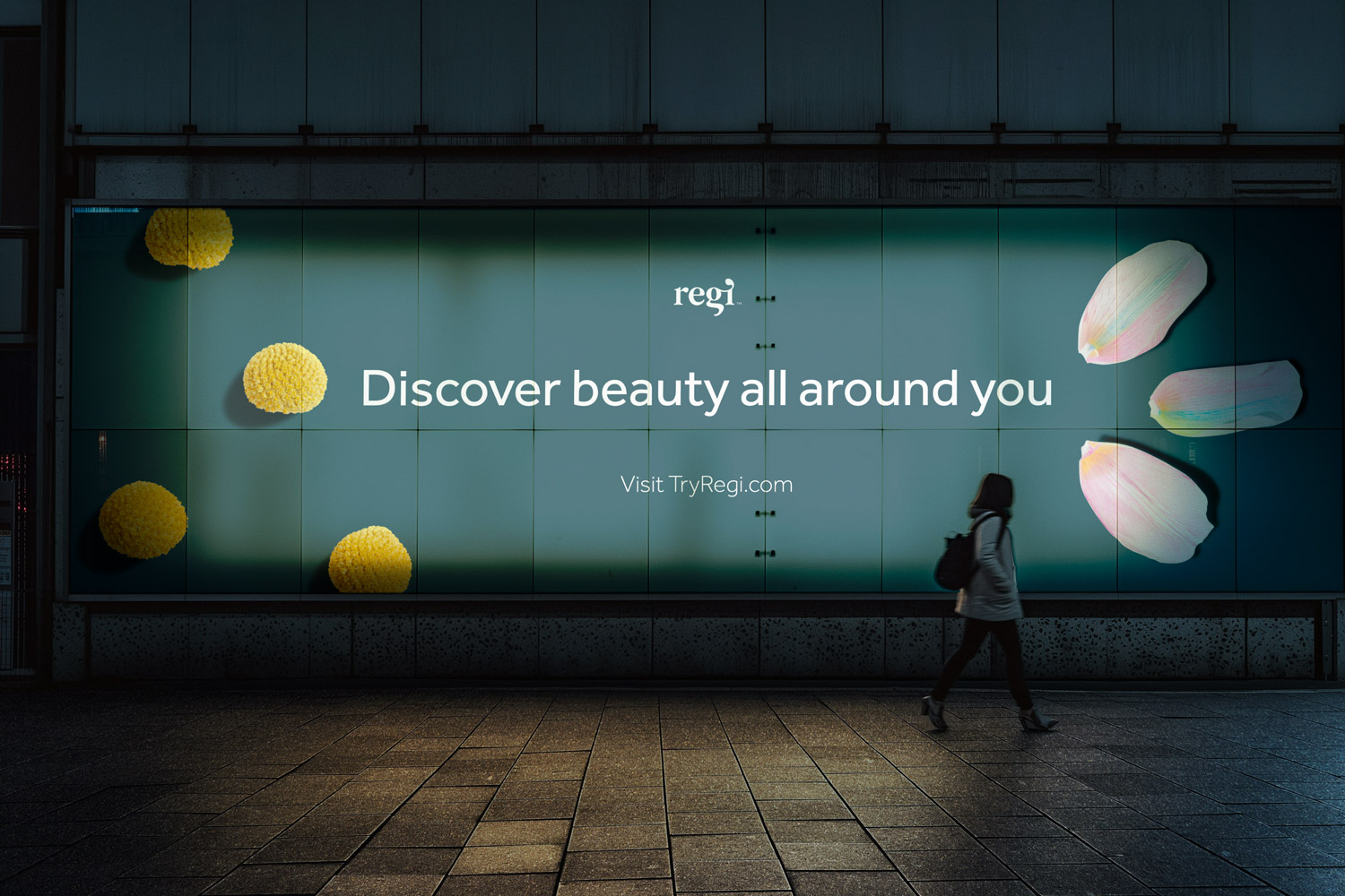 Outdoor advertisement with text 'Discover beauty all around you' surrounded by yellow flowers and pink petals, with a person walking past.