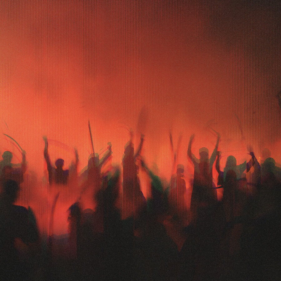 Silhouettes of people raising sticks and hands against a smoky red background, suggesting a riot or protest scene.