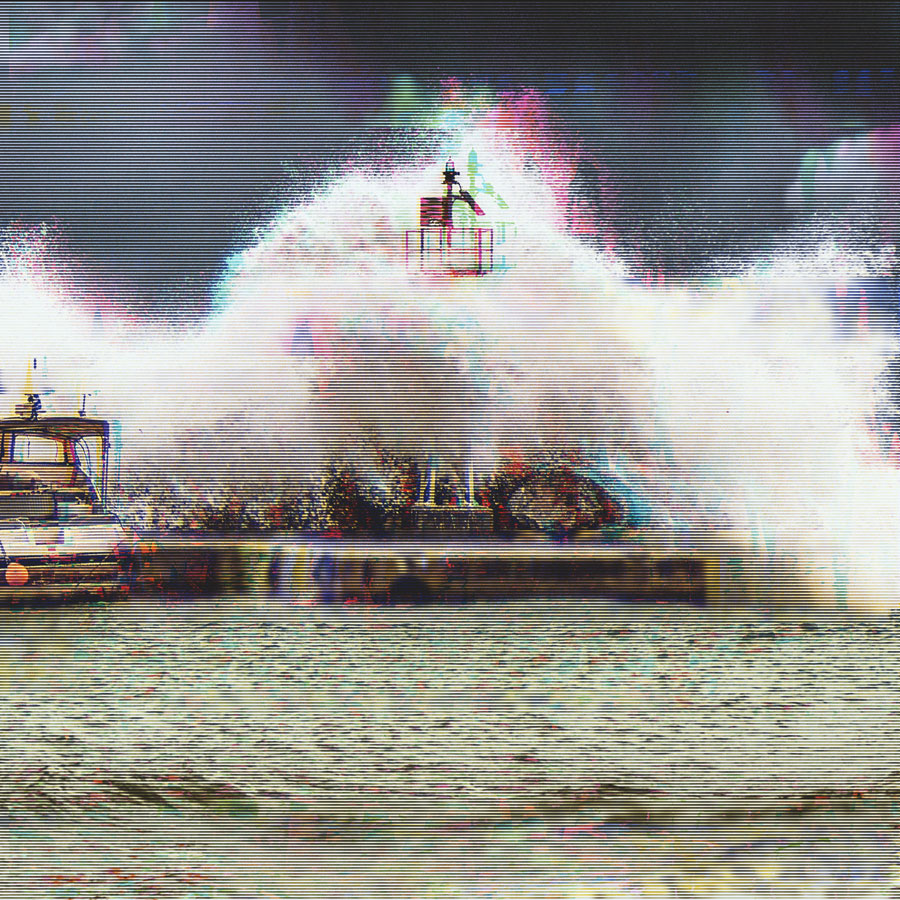 Large wave crashing against a pier with a small lighthouse or beacon and a boat nearby during stormy weather.
