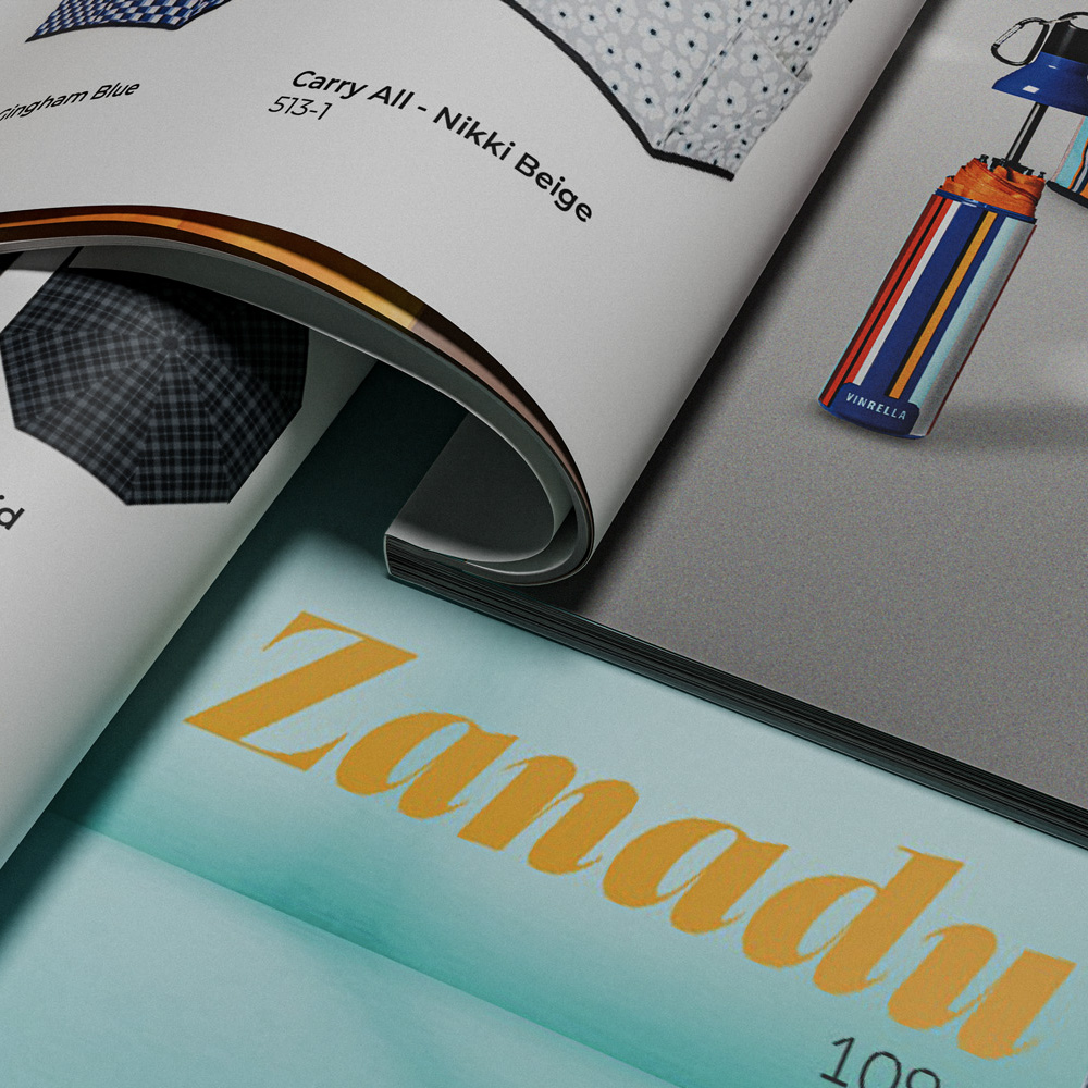 Close-up of a catalog page showing umbrellas and text including 'Carry All - Nikki Beige' and a striped umbrella case labeled 'Vinrella'.